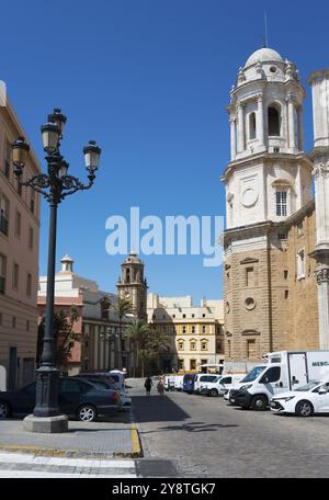 Bâtiments architecturaux avec une rue, des voitures et une lanterne sous un ciel bleu clair, dans le centre l'Iglesia de Santiago Apostol, Apostol, église de S. Banque D'Images