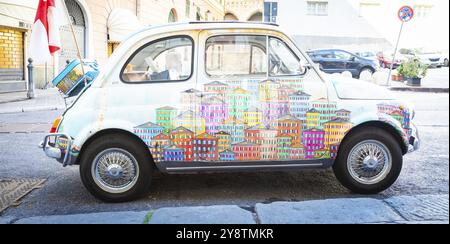 Gênes, Italie, 6 août 2023 : voiture Fiat 500 d'époque peinte avec un paysage urbain traditionnel de la région Ligurie, destination de voyage en Italie, Europe Banque D'Images