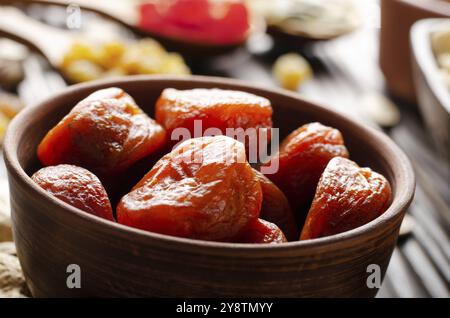 Abricots séchés déshydratés dans un bol en argile sur une table de cuisine en bois la nourriture Banque D'Images