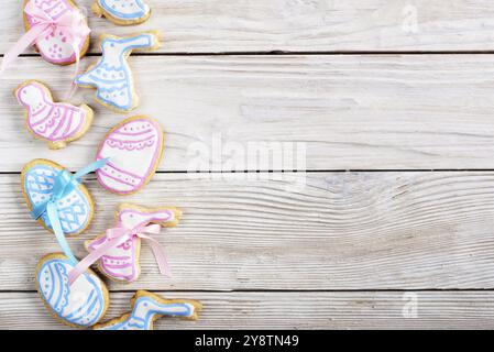 Biscuits givrés de Pâques en forme d'œuf de poulet et de lapin sur fond de table blanc en bois plat poser maquette horizontale avec espace de copie Banque D'Images