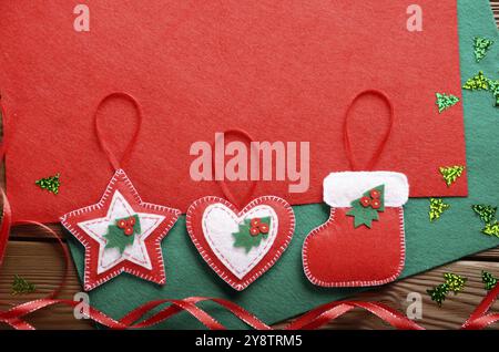 Rustique fait main de décorations de Noël en rouge et feutre vert sur table en bois Banque D'Images