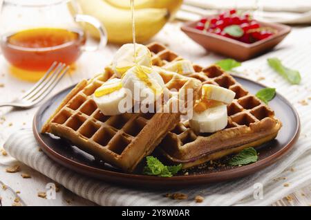 Gaufres belges croustillantes faites maison servies avec de la banane et du miel Banque D'Images