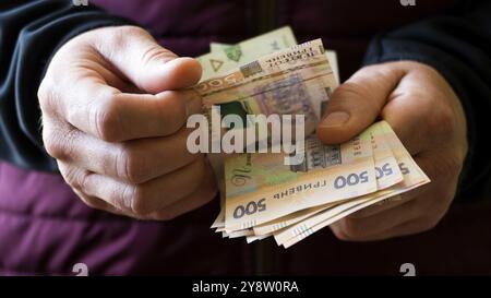 Les hommes blancs comptent Ukrainian hryvnia cinq cents billets dans ses mains Banque D'Images