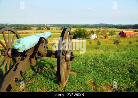 Un canon de l'époque de la guerre de Sécession est perché sur une colline, surplombant les terres agricoles du parc militaire national de Gettysburg, qui fait partie du champ de bataille historique Banque D'Images