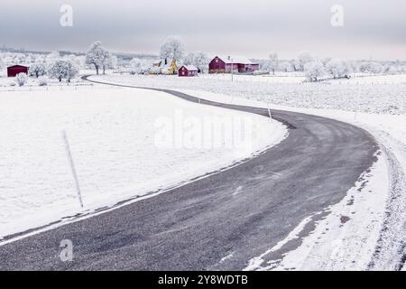 Route de campagne sinueuse dans un paysage rural hivernal Banque D'Images