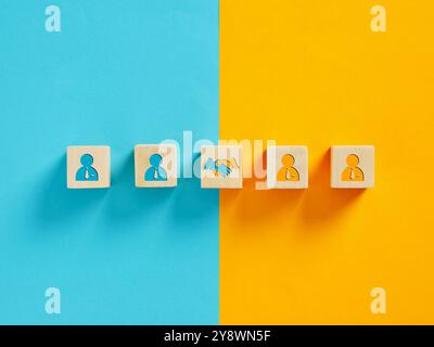 Symbole de poignée de main représentant un accord ou un partenariat réussi entre deux équipes commerciales sur fond bleu et jaune. Banque D'Images