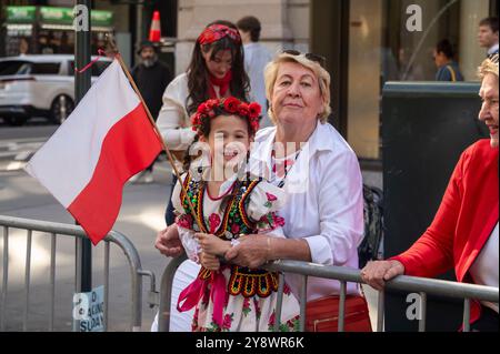 New York, États-Unis. 06 octobre 2024. Une jeune fille vêtue de vêtements traditionnels polonais portant le drapeau polonais regarde la parade Pulaski Day sur la Cinquième Avenue à New York. (Photo de Ron Adar/SOPA images/SIPA USA) crédit : SIPA USA/Alamy Live News Banque D'Images