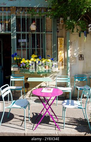 Table rose et chaises vert pastel devant le plus ancien restaurant de Paris. Belles fleurs jaunes, bleues et violettes vives. Coquelicot bleu, jacinthe Banque D'Images