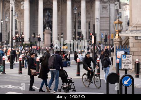 Piétons et cyclistes devant le Royal Exchange à la jonction de Bank et Cornhill dans la City de Londres, le quartier financier historique de la capitale (alias « The Square Mile »), le 4 octobre 2024, à Londres, en Angleterre. Banque D'Images