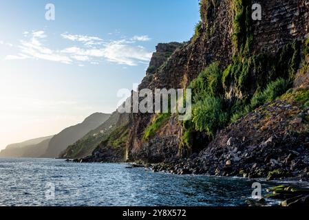 Côte rocheuse avec des montagnes tombant dans la mer et des vagues se brisant sur la falaise à Madère Portugal Banque D'Images