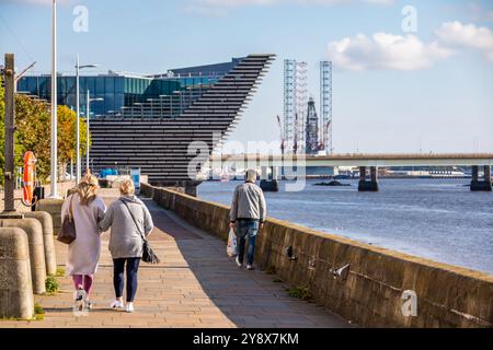 Dundee City, Écosse. Les gens marchent le long du sentier de la rivière Tay, avec le Victoria and Albert Museum, le pont de Tay Road et une plate-forme pétrolière en arrière-plan Banque D'Images