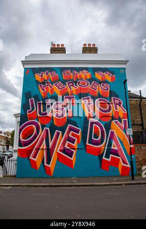 Une maison victorienne à Brixton avec les mots « We Can Be Heroes Just for One Day » dans un graffiti coloré de Street art - Londres le 29 septembre 2024. Banque D'Images