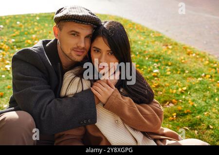 Un couple chaleureux et affectueux profite d'une journée d'automne paisible au milieu de feuilles colorées. Banque D'Images