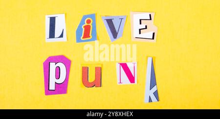 Phrase Live Punk dans un journal coloré découpée typographie de style sur fond jaune vif. Concept style de vie, musique live, mode de vie, attitude. Banque D'Images