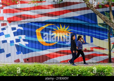 Kuala Lumpur, Malaisie. 03 Oct, 2024. Des femmes vues marcher devant une fresque murale du drapeau malaisien à Kuala Lumpur. La vie quotidienne à Kuala Lumpur. (Photo Faris Hadziq/SOPA images/SIPA USA) crédit : SIPA USA/Alamy Live News Banque D'Images