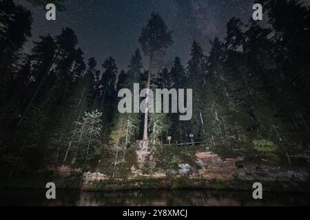 Paysage estonien, scène de nuit, rive escarpée de la rivière Ahja et grotte, ciel étoilé. Banque D'Images