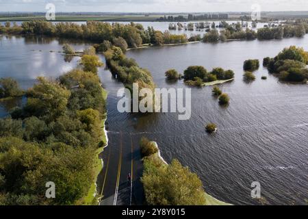 Un résident local vérifie l'A1101 à Welney dans le Norfolk qui est submergée par les inondations de la rivière Old Bedford et de la rivière Delph, laissant les habitants face à une déviation de 35 miles. Les orages et les fortes pluies peuvent perturber les transports dans certaines parties du sud de l'Angleterre et du pays de Galles, après qu'un avertissement d'orage jaune ait été émis par le met Office lundi après-midi dans une grande partie du sud du pays de Galles, du sud-ouest de l'Angleterre et dans certaines parties du sud de l'Angleterre. Date de la photo : lundi 7 octobre 2024. Banque D'Images