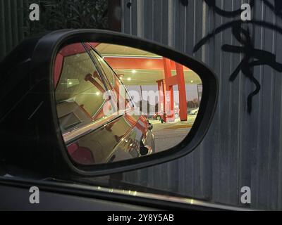 Petrol station reflected on a rear view mirror. Stock Photo