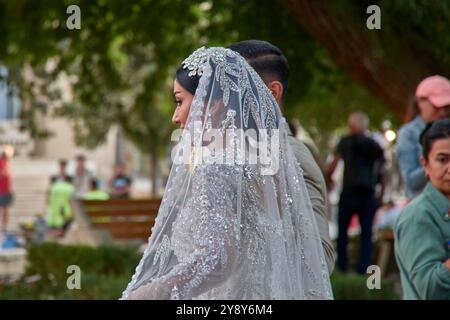 Boukhara, Ouzbékistan ; septembre, 19,2024:un moment romantique de jeunes mariés se promenant dans les rues anciennes de Boukhara, Ouzbékistan. Le couple, habillé Banque D'Images