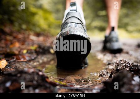 Gros plan d'une chaussure de coureur s'enfonçant dans la boue sur un sentier Banque D'Images