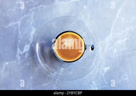 Café expresso dans une tasse en verre et soucoupe, pris d'en haut Banque D'Images