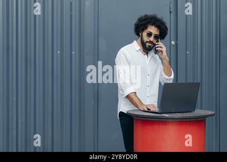 Homme d'affaires arabe africain réussi travaillant sur ordinateur portable en ligne dans le terminal de dock. Ventes Banque D'Images