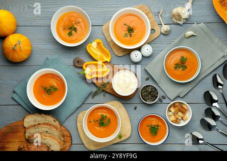 Composition plate de pose avec une délicieuse soupe de citrouille sur une table en bois gris Banque D'Images