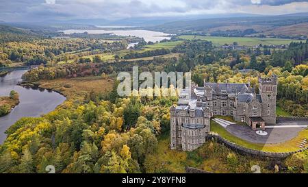 Château de Carbisdale Sutherland Écosse entouré d'arbres colorés en automne Kyle of Sutherland au loin Banque D'Images