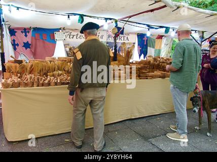 Étal de marché vendant des ustensiles de cuisine en bois avec des acheteurs touristiques pendant la semaine El CID fiestas Paseo del Espolón Burgos Castille et León Espagne Banque D'Images