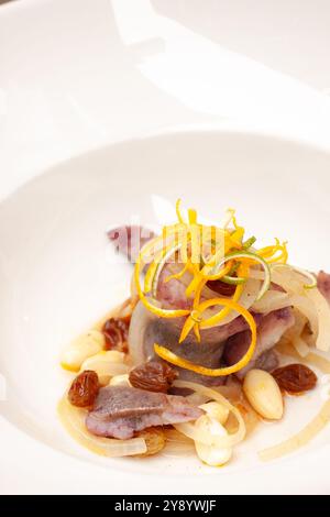 Plat de hareng saumuré élégant servi avec des amandes et des raisons et une touche d'orange la veille de Noël polonaise Banque D'Images