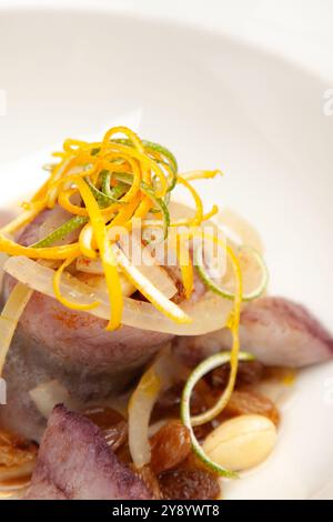 Plat de hareng saumuré élégant servi avec des amandes et des raisons et une touche d'orange la veille de Noël polonaise Banque D'Images