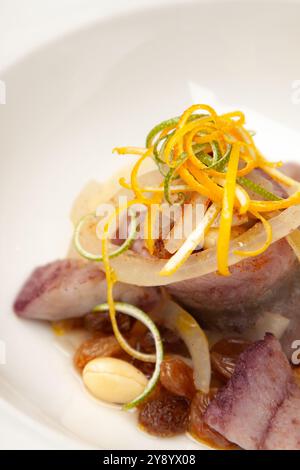 Plat de hareng saumuré élégant servi avec des amandes et des raisons et une touche d'orange la veille de Noël polonaise Banque D'Images