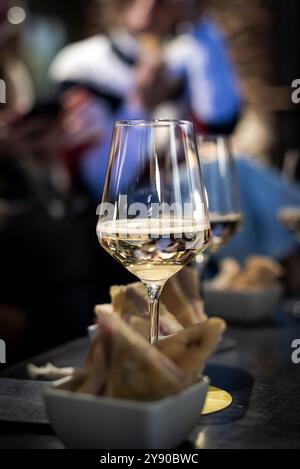 Verres à vin blanc pour un apéritif dans un bar à cocktails nocturne Banque D'Images