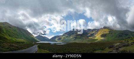 Panorama de jeu de lumière et d'ombre à travers l'herbe verte luxuriante des pentes de montagne à Doo Lough Valley, Glencullin Mountain, comté de Mayo, Irlande Banque D'Images