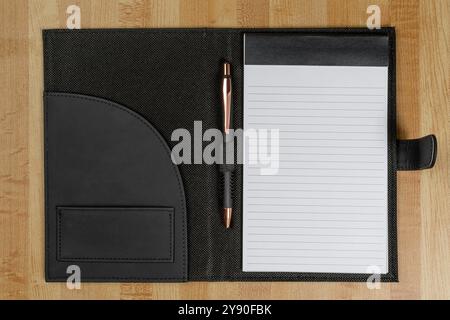 Plan horizontal d'un folio de bloc juridique junior avec épingle d'encre sur un bureau en bois. Banque D'Images