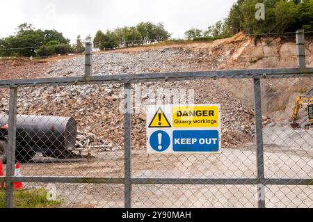 Travaux de carrière avec tas de pierres et clôture de sécurité avec danger et panneau d'interdiction d'entrer près du hameau de Tynron à Dumfries et Galloway en Écosse Banque D'Images