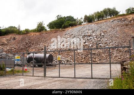 Travaux de carrière avec tas de pierres et clôture de sécurité avec danger et panneau d'interdiction d'entrer près du hameau de Tynron à Dumfries et Galloway en Écosse Banque D'Images