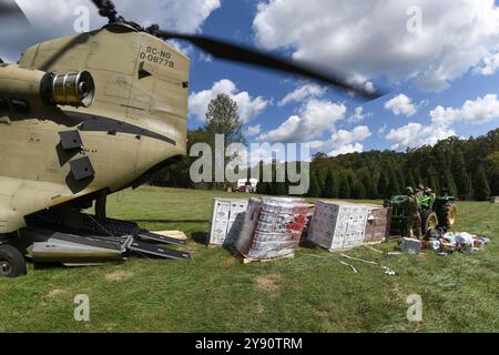 Comté de Catawba, États-Unis. 02 octobre 2024. Les soldats de l'armée américaine, affectés au bataillon de l'aviation du 238th Aviation Regiment de la Garde nationale de l'armée de Caroline du Sud, déchargent des palettes d'eau d'un hélicoptère CH-47F Chinook pour les survivants de l'ouragan Helene, le 2 octobre 2024, dans le comté de Catawba, en Caroline du Nord. Crédit : SFC Roberto Di Giovine/US Army/Alamy Live News Banque D'Images