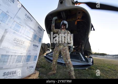 Greenville, États-Unis. 02 octobre 2024. Les soldats de l'armée américaine, affectés au bataillon d'aviation du 238e régiment d'aviation de la Garde nationale de Caroline du Sud, chargent des palettes d'eau dans un hélicoptère CH-47F Chinook pour les survivants de l'ouragan Helene, le 2 octobre 2024, à Greenville, Caroline du Sud. Crédit : SFC Roberto Di Giovine/US Army/Alamy Live News Banque D'Images