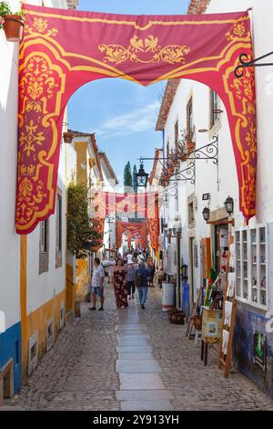 Une rue pittoresque dans la petite ville de Óbidos, avec ses décorations médiévales et ses petites boutiques artisanales, Portugal. Banque D'Images