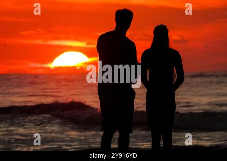 Île de Palms, États-Unis. 07 octobre 2024. Un couple, silhouetté par le lever du soleil, s’arrête pour regarder sur la plage de Wild Dunes Resort, le 7 octobre 2024 à Isle of Palms, Caroline du Sud. Crédit : Richard Ellis/Richard Ellis/Alamy Live News Banque D'Images