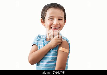 Portrait, heureux et gamin avec plâtre en studio isolé sur un fond blanc. Visage, sourire et garçon enfant avec bandage après vaccin, blessure ou plaie fo Banque D'Images