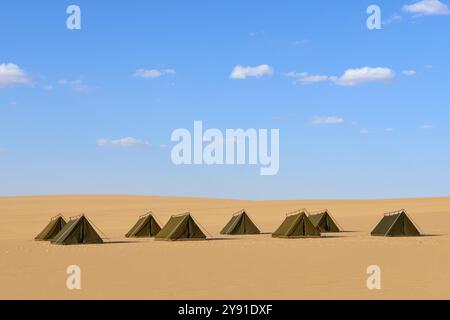 Rangée de tentes dans un paysage désertique sablonneux sous un ciel bleu avec peu de nuages, Matruh, Grande mer de sable, désert libyen, Sahara, Egypte, Afrique du Nord, Afrique Banque D'Images