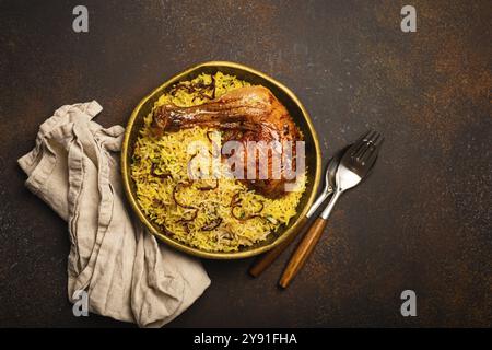 Délicieux plat indien de poulet Biryani avec riz basmati dans un ancien bol en laiton métallique sur une table sombre arrière-plan rustique. Cuisine traditionnelle non végétarienne o Banque D'Images