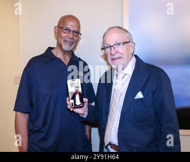 Los Angeles, Californie, États-Unis. 3 octobre 2024. L'artiste Michael Warren et le réalisateur/cinéaste Harrison Engle tiennent un téléphone portable avec l'artiste Jie Geng, Los Angeles Beverly Arts (LABA) Overseas Envoy, présent par vidéoconférence, à la Luskin Gallery Exhibition à l'UCLA à Los Angeles, en Californie. Crédit : Sheri Determan Banque D'Images