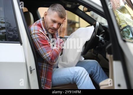 Homme blessé près d'un airbag ouvert dans une automobile après un accident de voiture Banque D'Images