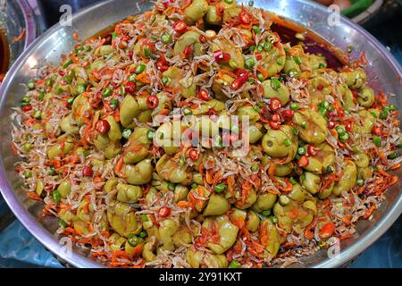 Plateau de cornichons marial vert aigre, Bouea macrophylla, en vente sur un stand de cuisine de rue thaïlandais, servi avec des crevettes séchées et du piment Banque D'Images