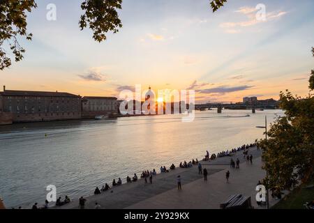 Coucher de soleil doré sur la Garonne avec vue sur le pont piétonnier Saint-Pierre, la place Saint-Pierre et la tombe de l'hôpital vu de la rivière Banque D'Images