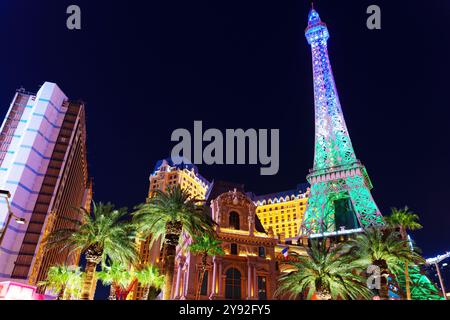 Las Vegas, Nevada - 13 avril 2024 : vue imprenable sur la réplique de la Tour Eiffel illuminée la nuit, entourée d'hôtels animés de Las Vegas et de palmiers. Banque D'Images