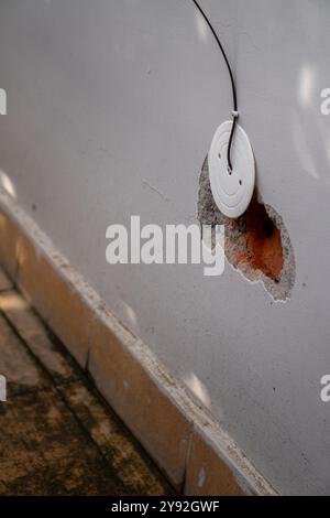 Un trou percé dans un mur pour l'installation de fils de câbles et de fibres optiques, montrant des trous de briques exposés, représentant le développement urbain à Dehradun C. Banque D'Images